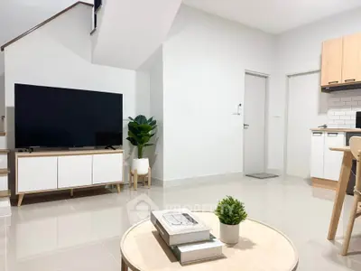 Modern living room with sleek TV setup and minimalist decor in a bright, open space.