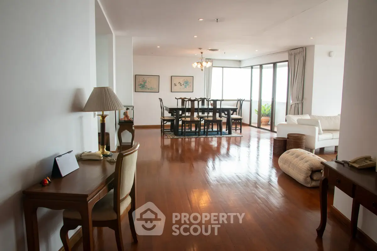 Spacious living room with elegant wooden flooring and large windows offering natural light.