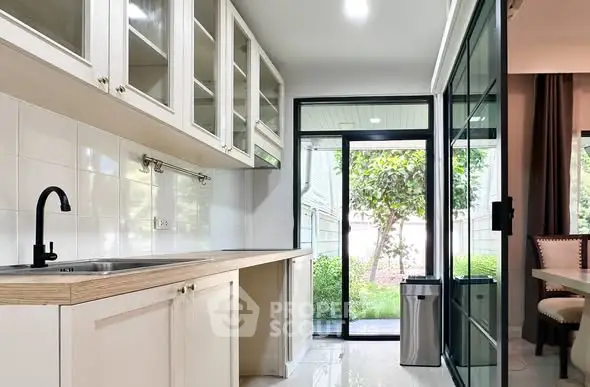 Modern kitchen with sleek cabinetry and garden view