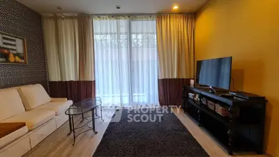 Cozy living room with modern decor and large window for natural light