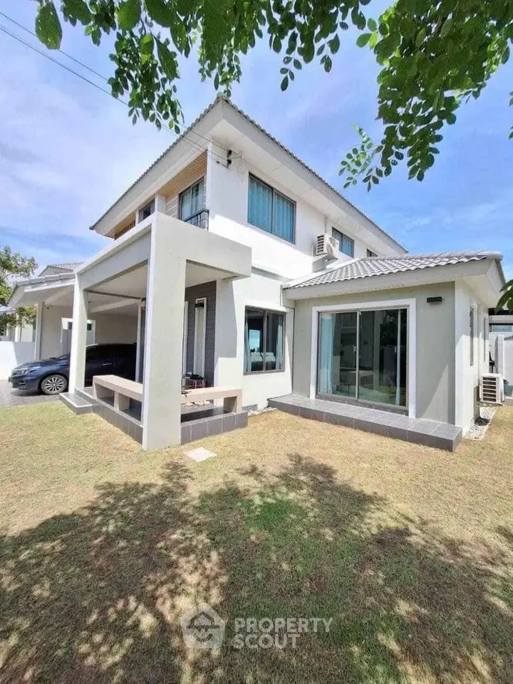 Modern two-story house with spacious lawn and sleek architectural design