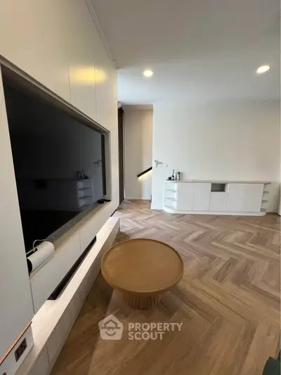 Modern living room with sleek TV setup and stylish wooden flooring