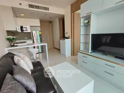 Modern living room with sleek furniture and open kitchen layout in a stylish apartment.