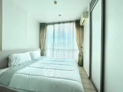 Bright and airy bedroom with large window and modern furnishings in a stylish apartment.