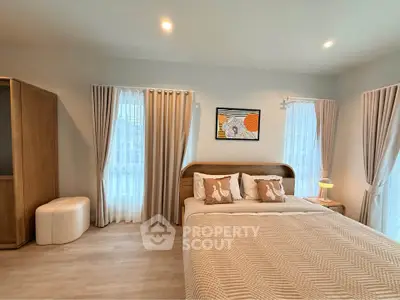 Elegant bedroom with cozy decor and natural light, featuring stylish curtains and modern furniture.
