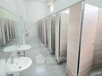 Spacious public restroom with multiple stalls and modern sinks