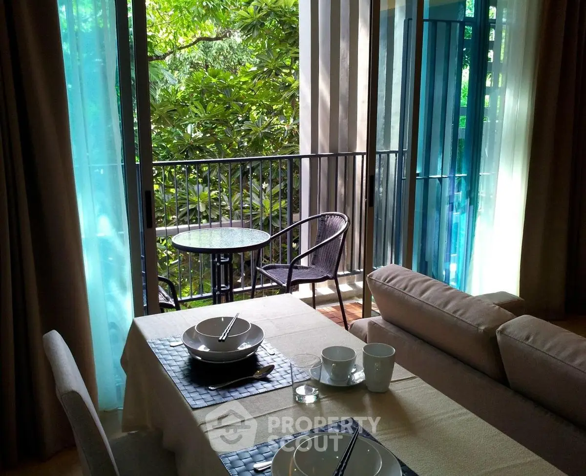 Charming dining area with balcony view, perfect for relaxing and enjoying nature.