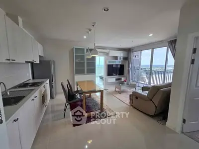 Spacious modern living room with open kitchen and balcony view