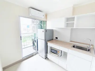 Modern kitchen with balcony view, featuring sleek appliances and ample storage space.