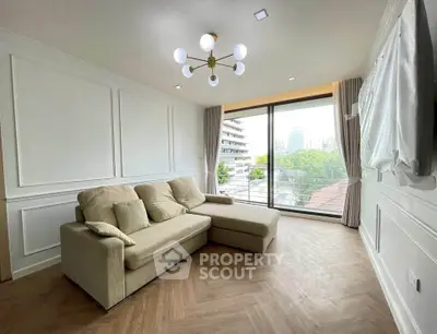 Spacious living room with modern decor and large window offering a stunning city view.