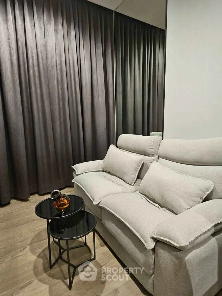 Cozy living room with plush sofa and elegant side tables, perfect for relaxation.