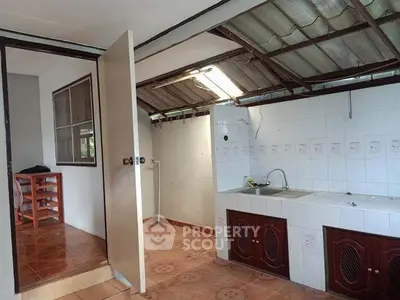 Charming rustic kitchen with open layout and natural light, featuring tiled floors and wooden cabinetry.