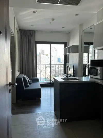 Modern apartment kitchen with open layout and city view balcony.