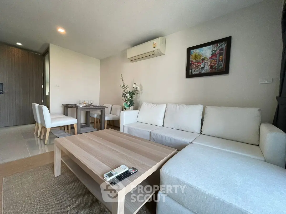 Modern living room with cozy white sofa and dining area in stylish apartment