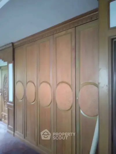 Elegant wooden paneling in a classic interior hallway with intricate design details.