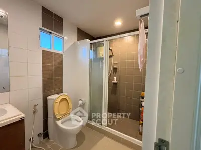Modern bathroom with shower and toilet in a contemporary home.