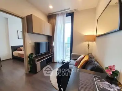 Modern living room with cozy sofa, TV, and bedroom view