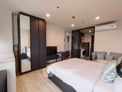 Modern bedroom with stylish furniture and in-room washing machine, perfect for urban living.