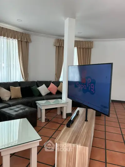 Spacious living room with modern TV setup and cozy sectional sofa.