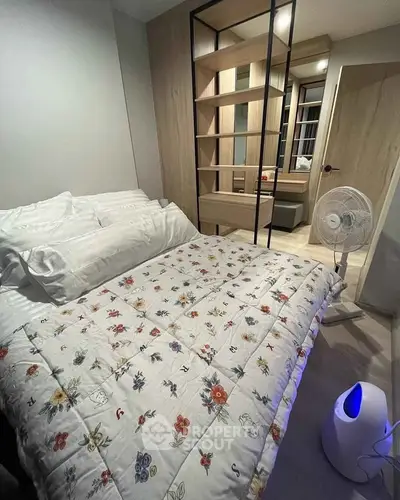 Cozy bedroom with floral bedding, modern decor, and stylish shelving unit.