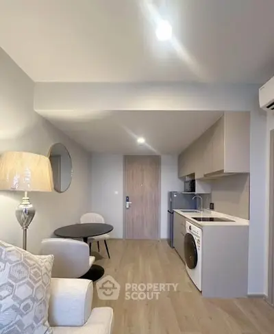 Modern open-plan living room with compact kitchen and stylish decor