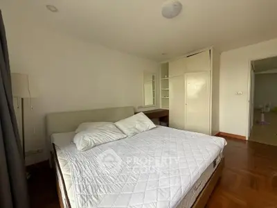 Spacious bedroom with elegant parquet flooring and ample storage space.