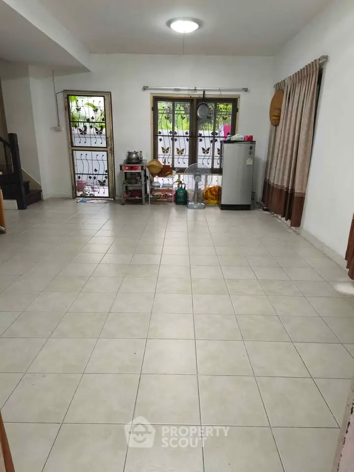 Spacious tiled living area with natural light and modern decor