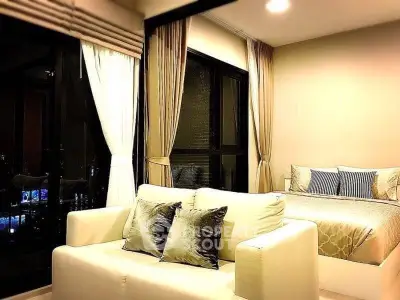 Luxurious studio apartment with elegant decor and city view, featuring cozy bed and stylish sofa.