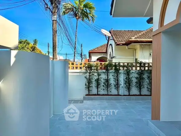 Charming exterior view of a modern home with lush greenery and clear blue sky.