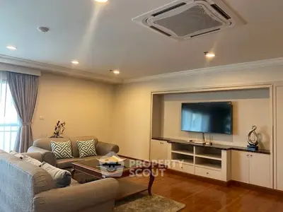 Spacious living room with modern decor and wall-mounted TV in a cozy apartment.