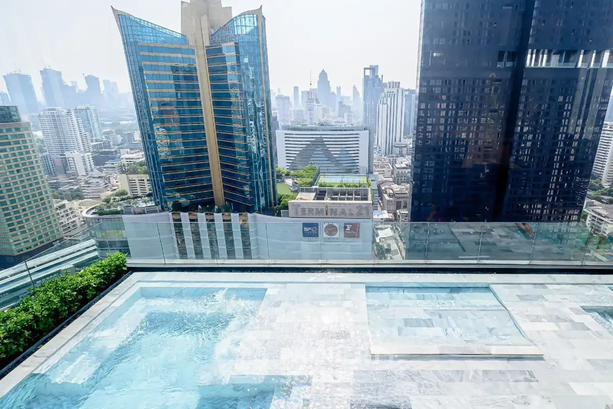 Luxurious rooftop pool with stunning city skyline view in modern high-rise building.