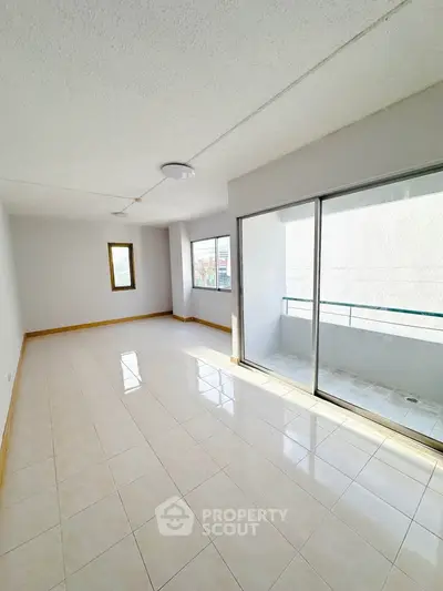 Spacious and bright living room with balcony access, perfect for modern living.