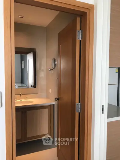 Modern bathroom with wooden door and sleek fixtures in a contemporary home.