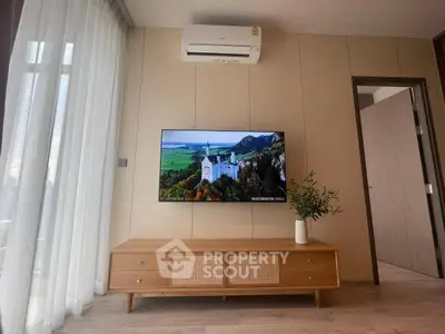 Modern living room with wall-mounted TV and stylish wooden cabinet under air conditioner.
