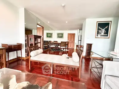 Spacious living room with elegant wooden flooring and stylish furniture in a modern apartment.