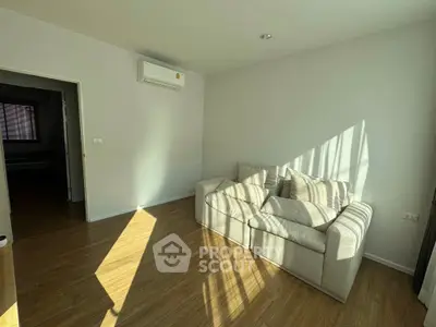 Bright living room with cozy sofa and wooden flooring