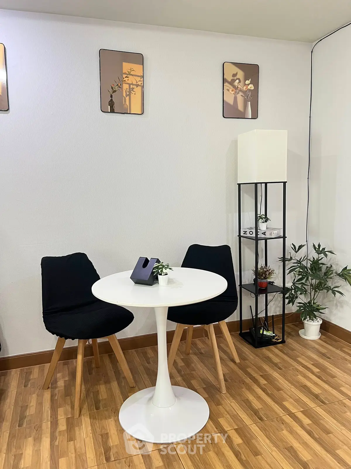 Chic modern dining area with stylish black chairs and round white table, perfect for cozy meals.