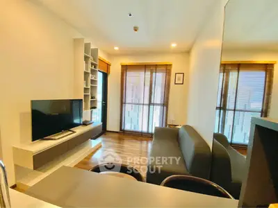 Modern living room with sleek furniture and large windows offering natural light.