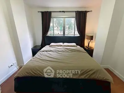 Cozy bedroom with large window and elegant curtains, perfect for relaxation.