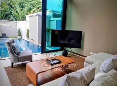 Luxurious living room with pool view, modern furniture, and large glass doors.