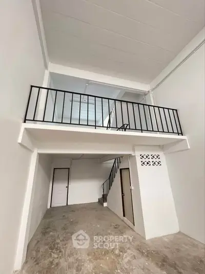 Spacious interior with high ceiling and mezzanine floor, ideal for creative use or storage.