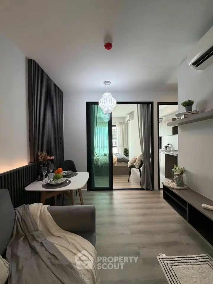 Modern living room with open layout and stylish decor, featuring a cozy dining area and sleek kitchen.