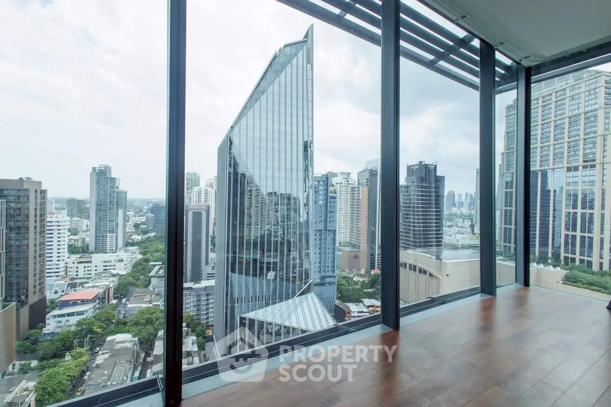 Stunning cityscape view from modern high-rise apartment with floor-to-ceiling windows.