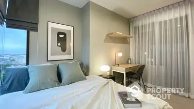 Modern bedroom with stylish decor and city view, featuring a cozy workspace and elegant lighting.