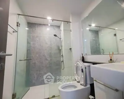 Modern bathroom with glass shower and sleek fixtures in a contemporary apartment.
