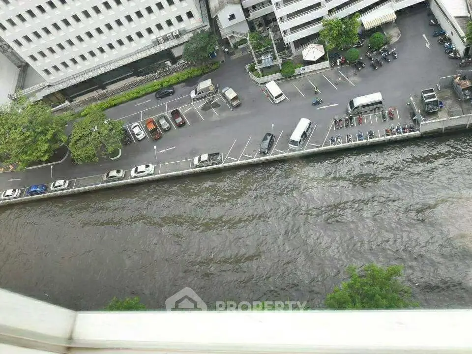 Aerial view of parking lot and canal beside a commercial building