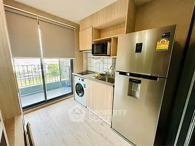 Modern kitchen with balcony, featuring stainless steel fridge and washing machine.