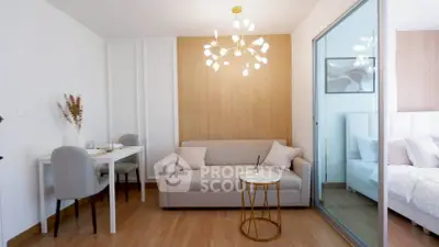 Modern living room with elegant chandelier and cozy sofa, adjacent to a stylish bedroom.