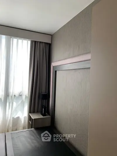 Modern bedroom with stylish headboard and natural light from large window