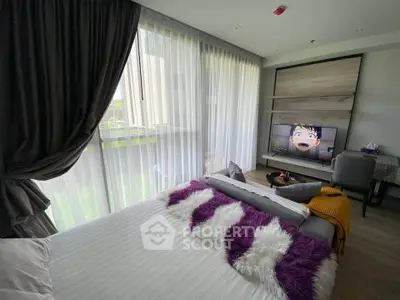 Modern bedroom with stylish decor and large window offering natural light